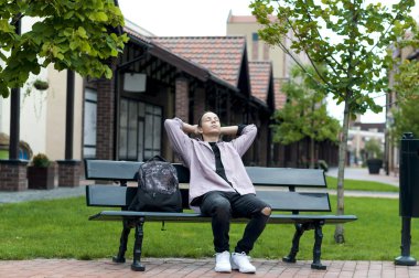 bir bankta oturan genç adam dinleniyor