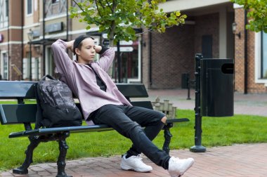 bir bankta oturan genç adam dinleniyor