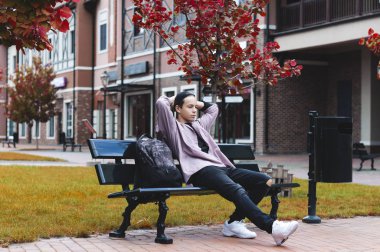 bir bankta oturan genç adam dinleniyor