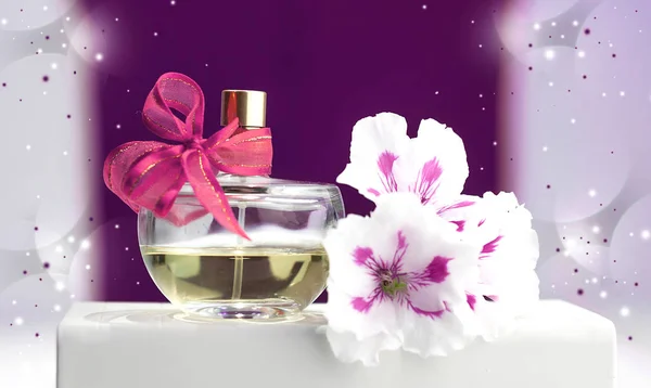 Frasco de perfume, violetas, sobre un fondo rosa — Foto de Stock