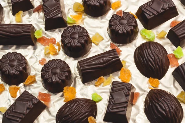 Caramelos de chocolate, frutas confitadas sobre un fondo claro —  Fotos de Stock