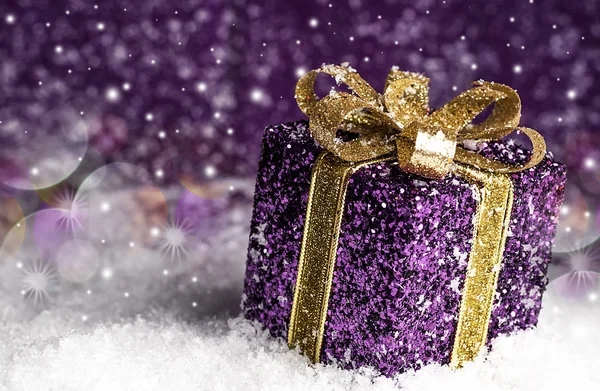 karlı bir arka plan üzerinde altın bir yay ile mor parlak Hediyelik