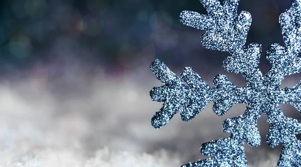 Floco de neve na neve em um fundo azul escuro — Fotografia de Stock