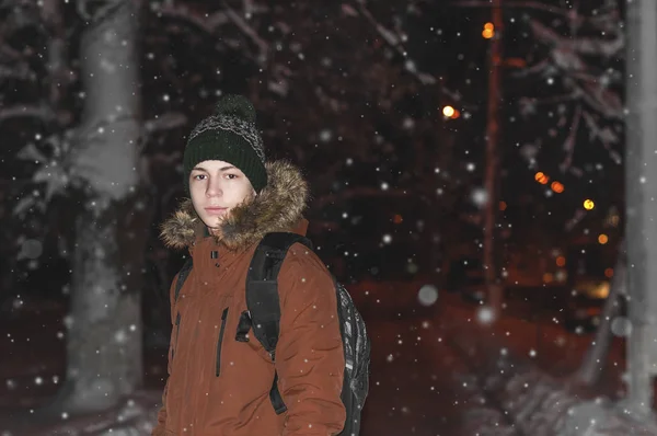 Young man on a city street during a snowfall — Stock Photo, Image