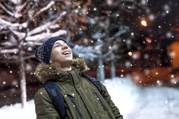 Happy young man on a city street during a snowfall — Stock Photo, Image