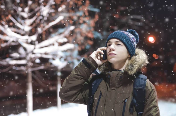 Young man with a phone in a city street in a frosty evening — Stock Photo, Image