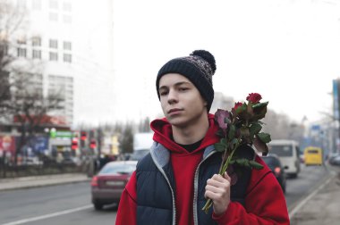 Bir buket gül bir şehir sokak üzerinde mutlu genç adam