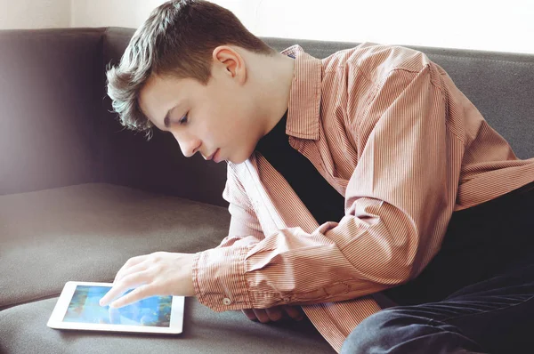 Teenager mit Tablet auf der Couch liegend — Stockfoto