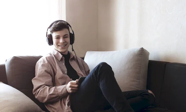Подросток в наушниках, слушающий музыку — стоковое фото