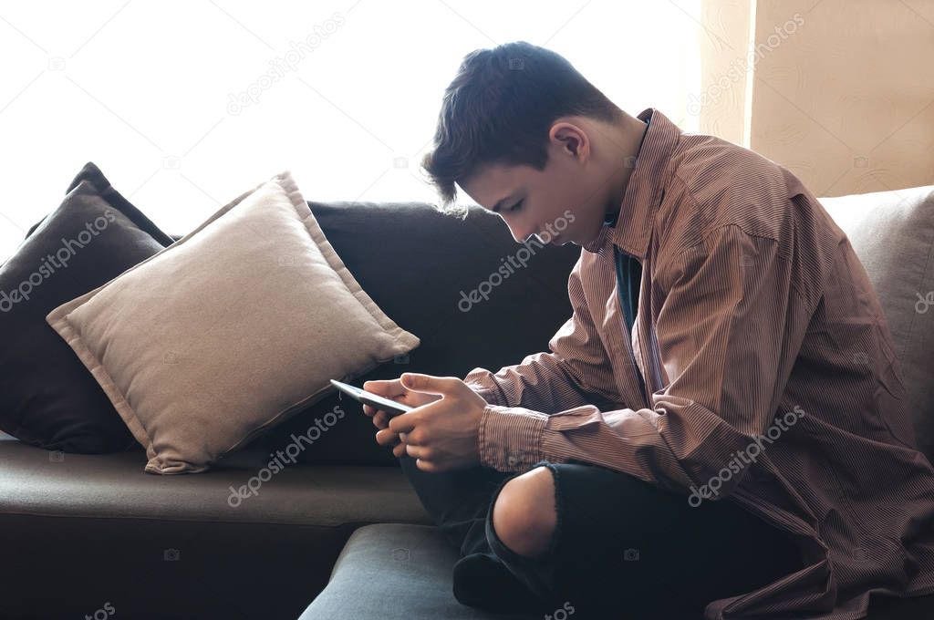 young man with a tablet sitting on the couch