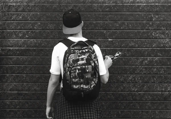 Adolescente com uma mochila de pé perto de uma parede — Fotografia de Stock