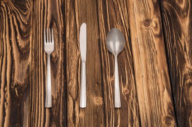 ahşap bir masa üzerinde eşit olarak katlanmış çatal bıçak takımı