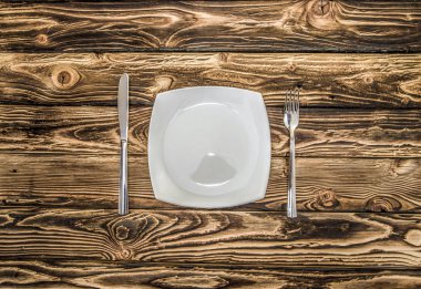 ahşap bir masa üzerinde eşit olarak katlanmış çatal bıçak takımı