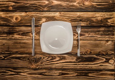 ahşap bir masa üzerinde eşit olarak katlanmış çatal bıçak takımı