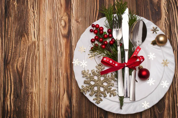 Weihnachtstisch gedeckt mit Tannenzweigen, Schleife und Schleife. — Stockfoto
