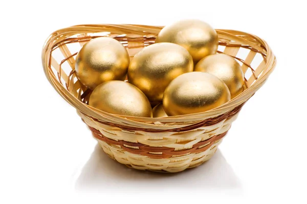 stock image golden eggs in a basket isolated on white background