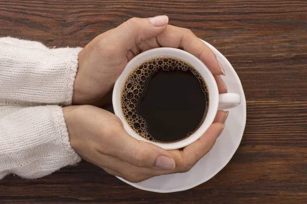 Mãos femininas segurando xícaras de café no fundo rústico — Fotografia de Stock