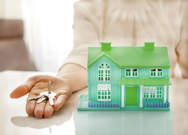 Home and house key on a female hand — Stock Photo, Image