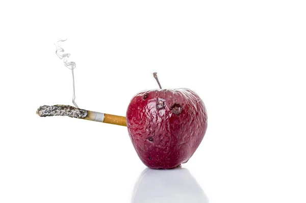 Pomme pourrie avec une cigarette, le concept de mal à fumer — Photo