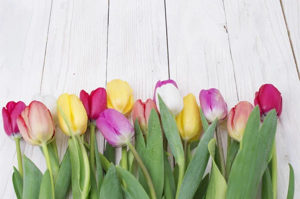 Ramo de tulipanes sobre tabla de madera rústica, decoración de Pascua — Foto de Stock