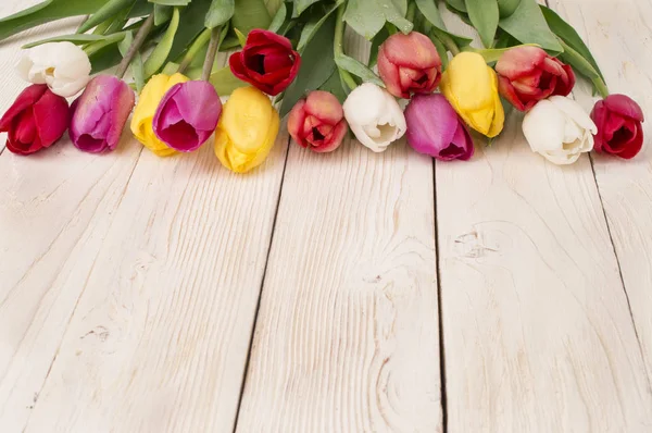 Ramo de tulipanes sobre tabla de madera rústica, decoración de Pascua — Foto de Stock