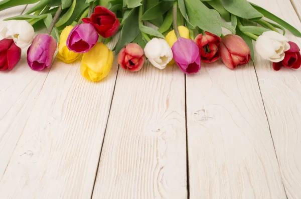 Ramo de tulipanes sobre tabla de madera rústica, decoración de Pascua — Foto de Stock