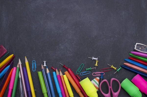 Fournitures scolaires sur fond tableau noir — Photo