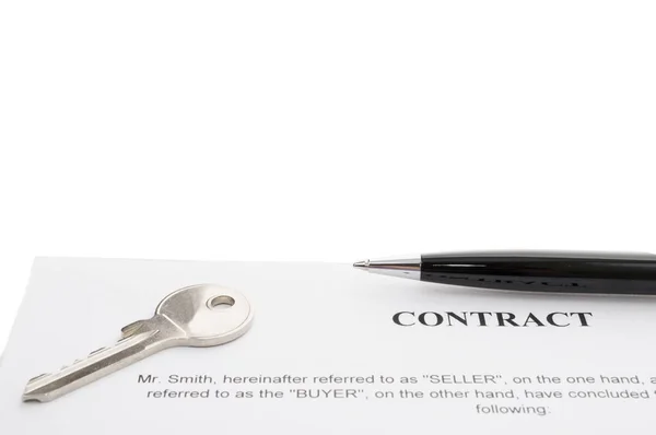 Chaves de uma nova casa e caneta no contrato . — Fotografia de Stock