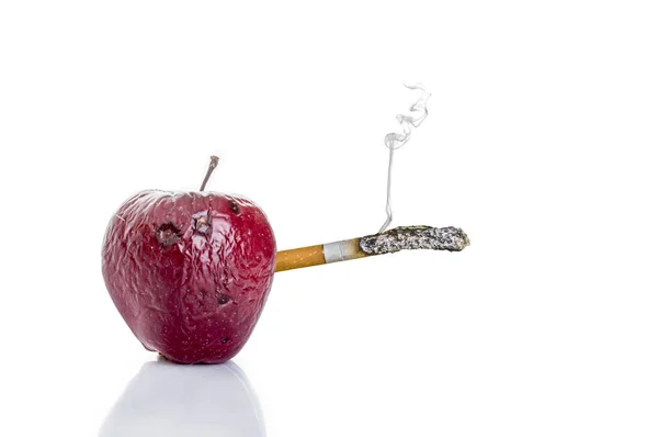 Pomme pourrie avec une cigarette, le concept de mal à fumer — Photo