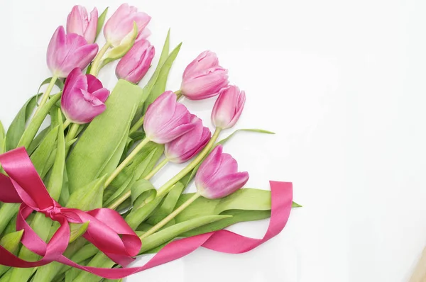 Tulipanes rosados con cinta rosa sobre un blanco — Foto de Stock