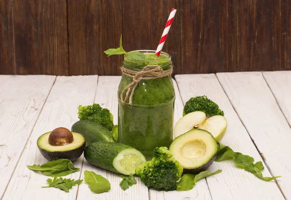 sağlıklı yeşil smoothie muz, ıspanak, avokado ve bir rustik bir cam şişe içinde salatalık ile