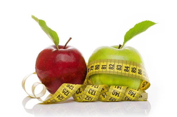 Zelené jablko a červené jablko s měřicí páskou na bílém pozadí — Stock fotografie