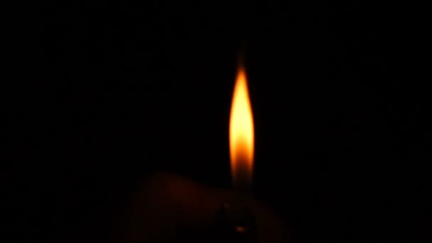 Feuerzeug leuchtet vor schwarzem Hintergrund in Zeitlupe auf — Stockvideo
