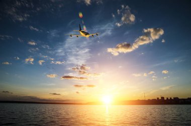 Gün batımında denize doğru güneş üzerinde uçan uçak tırmanıyor