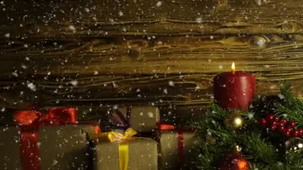 Hořící svíčka, vánoční větev a dárkové krabice na pozadí z broušeného drevisny — Stock video