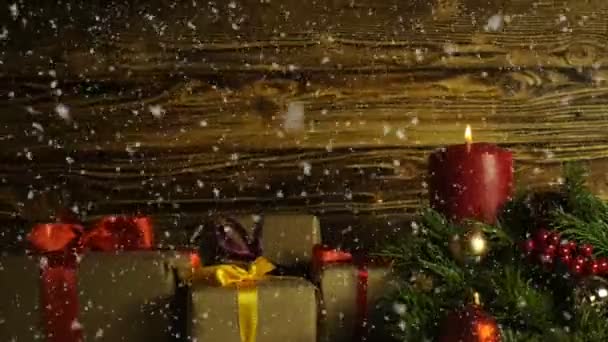 Yanan bir mum, bir kürk-ağaç dalı ve fırçalanmış drevisny bir arka plan üzerinde hediye kutuları — Stok video