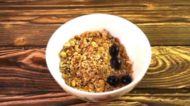 Ağır çekim bir porselen kase içine düşen meyveleri ile müsli