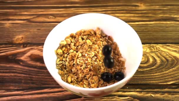 Muesli with berries falling into a porcelain bowl, Slow motion — Stock Video