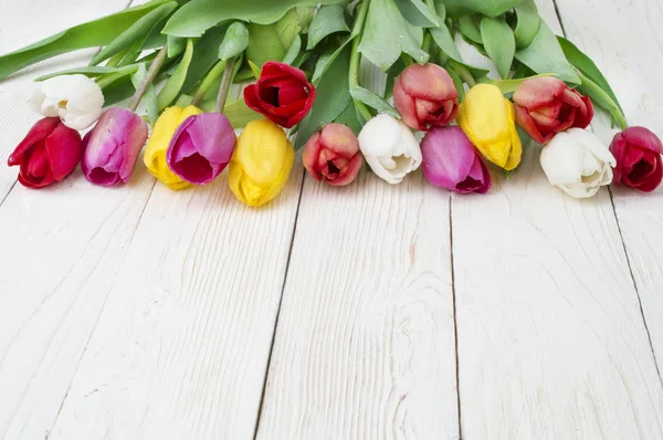 Ramo de tulipanes sobre tabla de madera rústica, decoración de Pascua — Foto de Stock