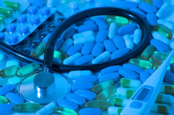 Tema da farmácia. Comprimidos isolados multicoloridos e cápsulas na superfície branca . — Fotografia de Stock