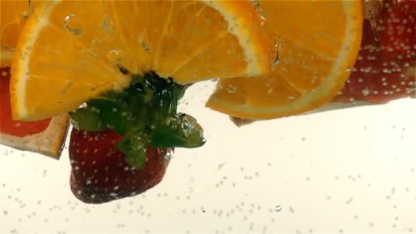 Fresh ripe berries and fruits fall into mineral water, slow motion — Stock Video