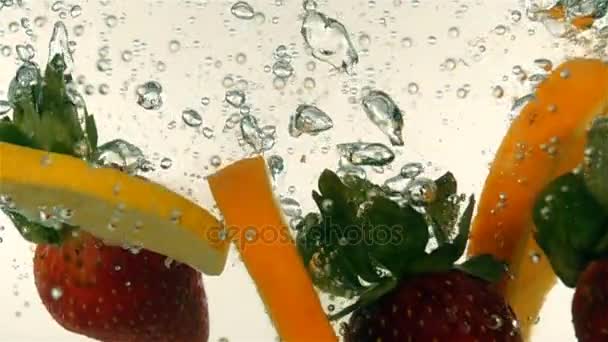 Fresh ripe berries and fruits fall into mineral water, slow motion — Stock Video