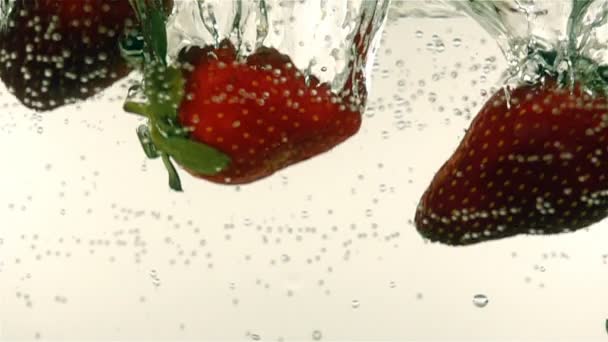 Fresh ripe berries and fruits fall into mineral water, slow motion — Stock Video