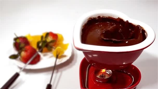 Fondue com chocolate e frutas, morangos cair em chocolate derretido, câmera lenta — Vídeo de Stock