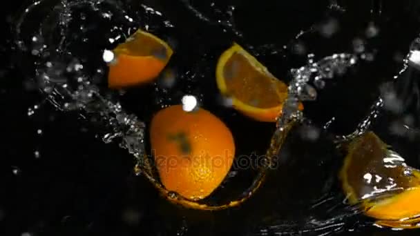 Апельсин падает в воду, замедленное движение — стоковое видео