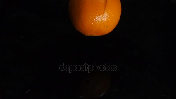 Апельсин падает в воду, замедленное движение — стоковое видео