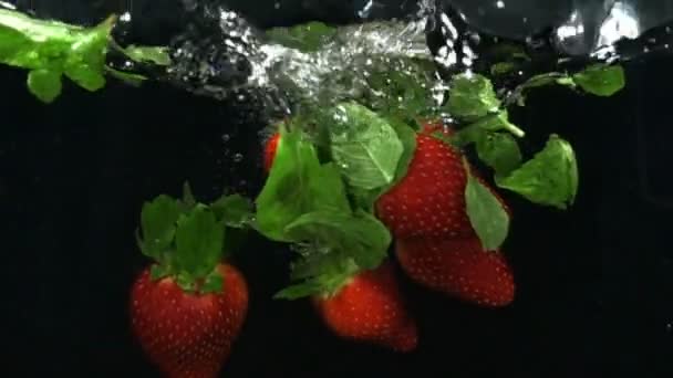 Verse rijpe bessen en vruchten vallen in mineraalwater, slow-motion — Stockvideo
