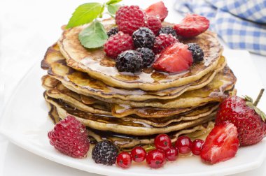 Çilek ve beyaz bir arka plan üzerinde akçaağaç şurubu ile lezzetli gözleme