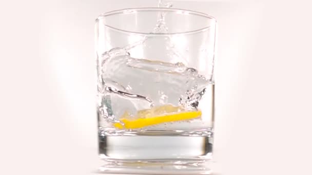 Лимон падает в воду, замедленная съемка — стоковое видео