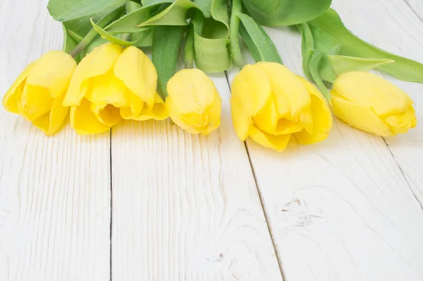 Ramo de tulipanes sobre tabla de madera rústica, decoración de Pascua — Foto de Stock
